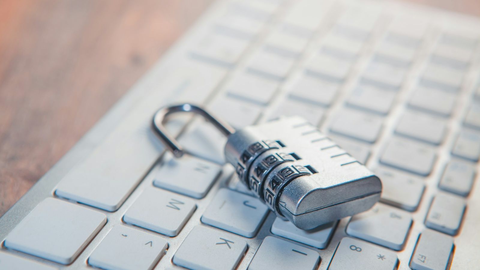 Combination padlock resting on a laptop keyboard